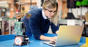 healthcare student reviewing medical documents on laptop in lab